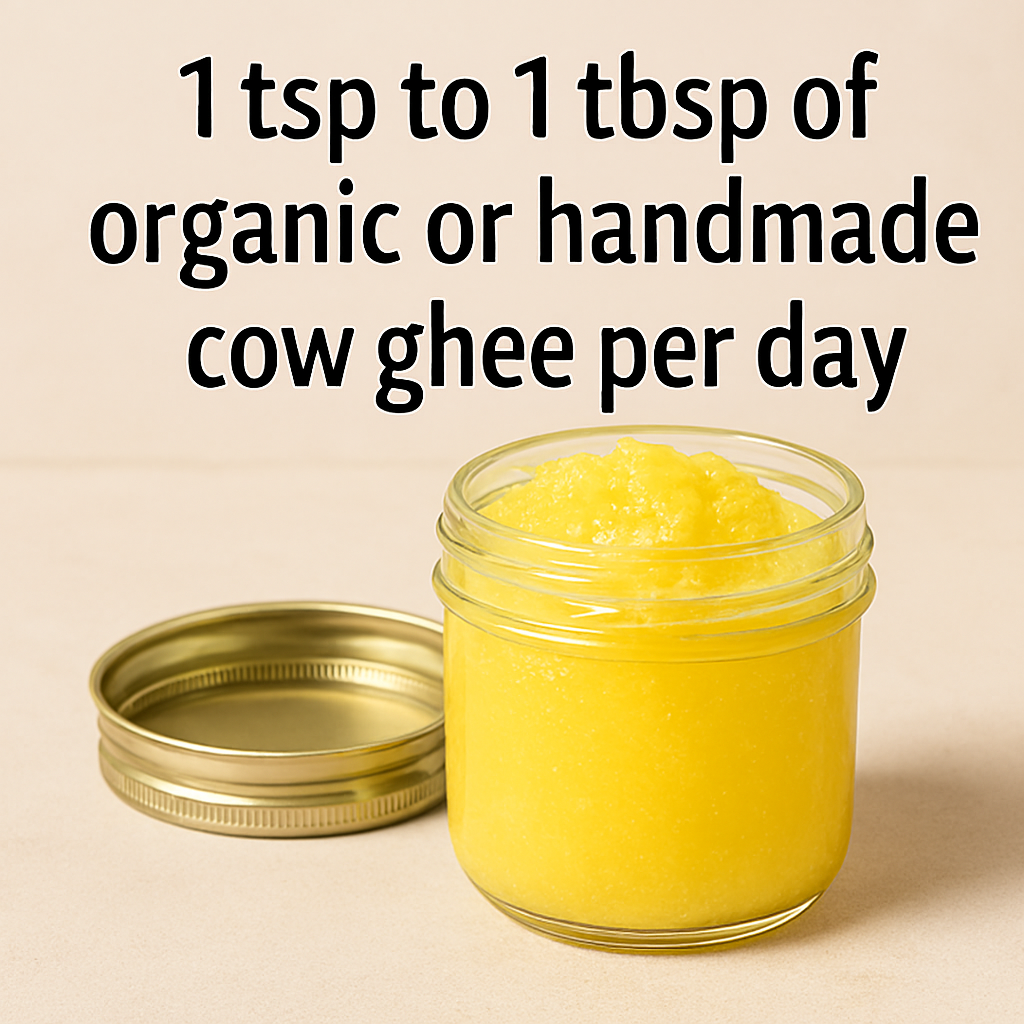 A glass jar filled with golden-yellow handmade cow ghee, placed beside its metallic lid on a beige surface. Text above reads “1 tsp to 1 tbsp of organic or handmade cow ghee per day.”